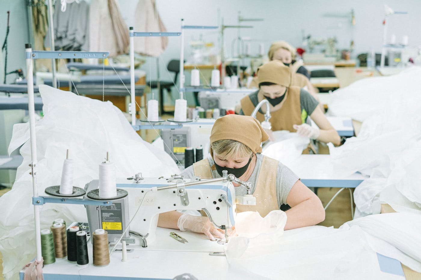 Garment workers sewing and checking quality in a textile workshop